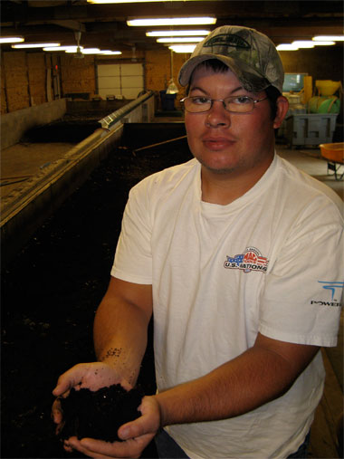 Bryan Shupe, holding compost made by worms.