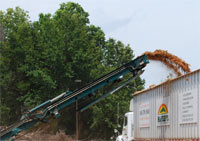 Chipped material being loaded into trucks