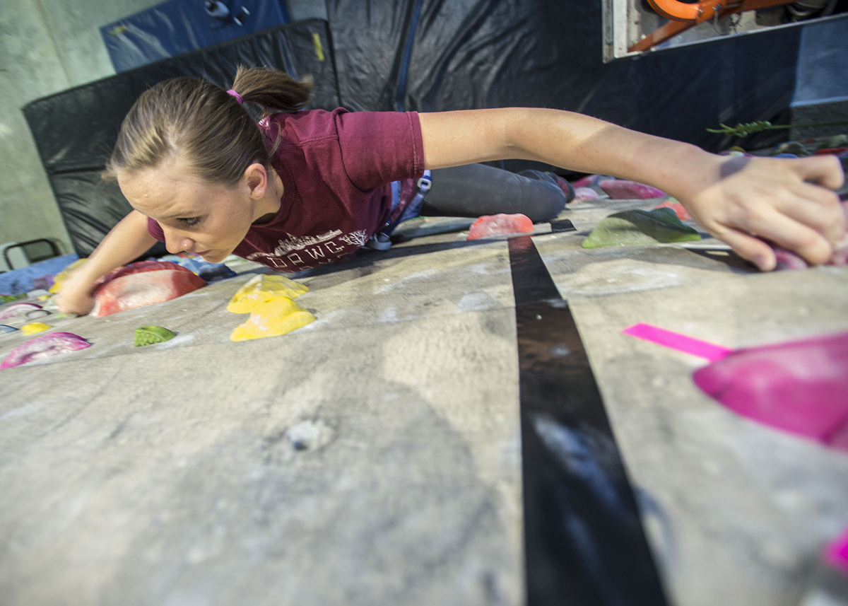 student climbing rock wall