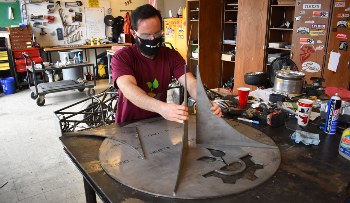 person works to fabricate a micro-wind turbine 