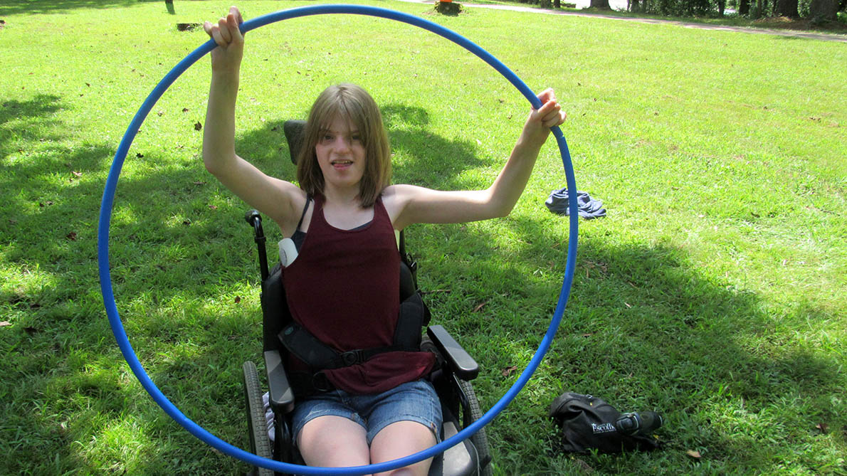 girl in a wheelchair holding a hoop