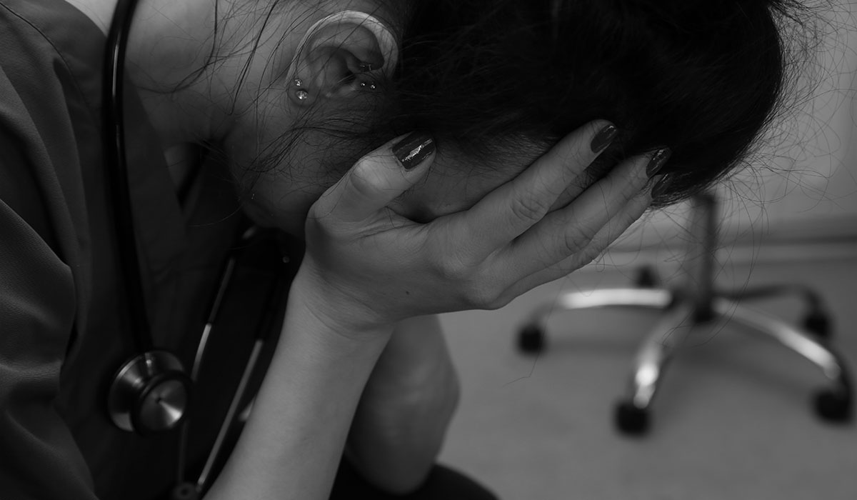 female nurse sitting with her head in her hands