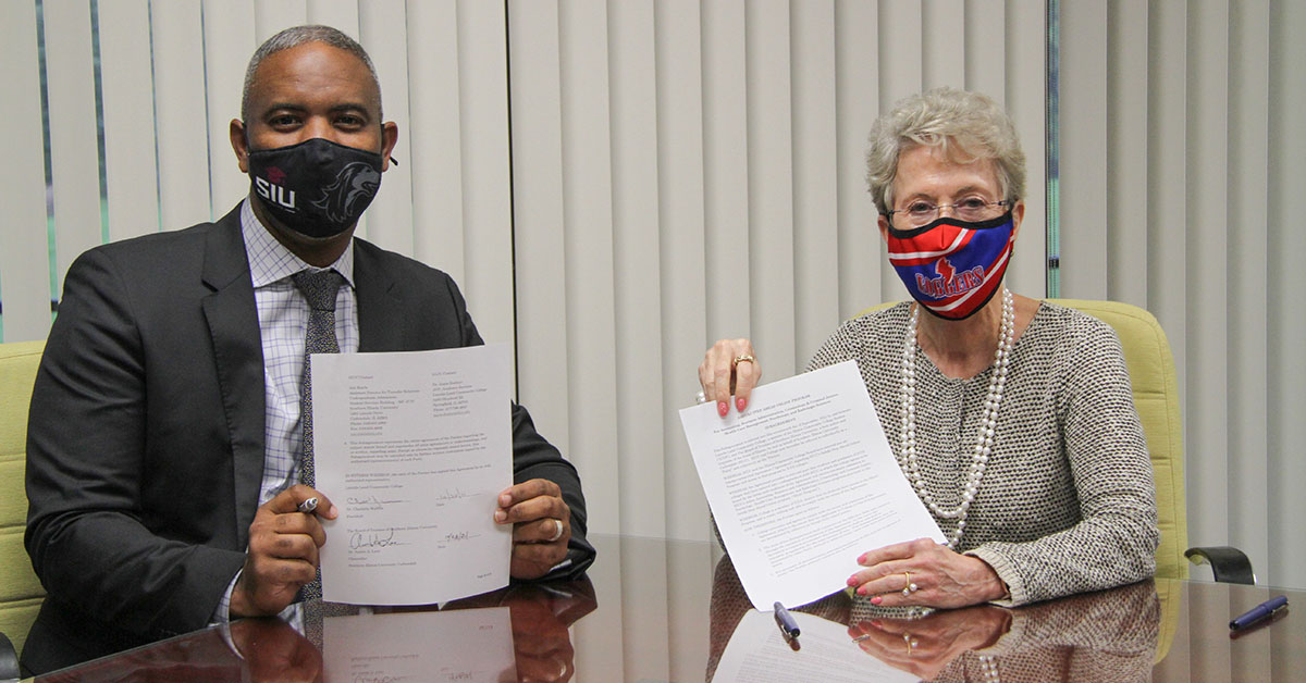 Austin Lane, chancellor of Southern Illinois University Carbondale, and Charlotte Warren, president of Lincoln Land Community College, show off their institutions’ agreement on Saluki Step Ahead