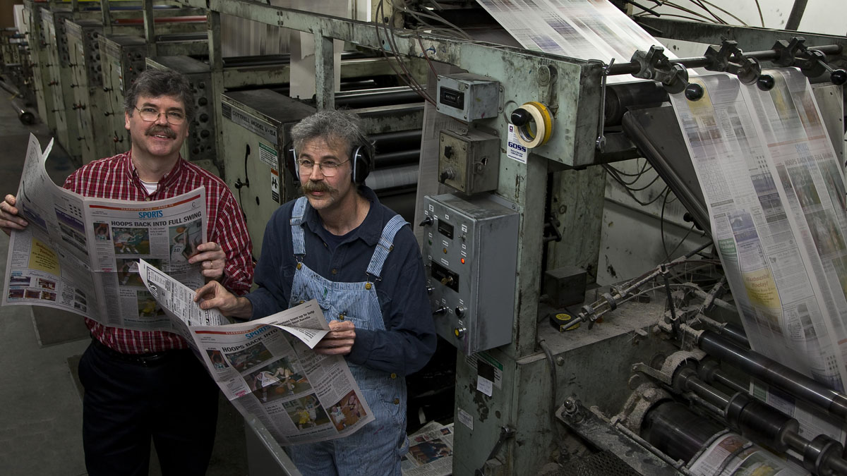 Brothers John (left) and Art Cullen review a copy of The Storm Lake Times hot off the presses.