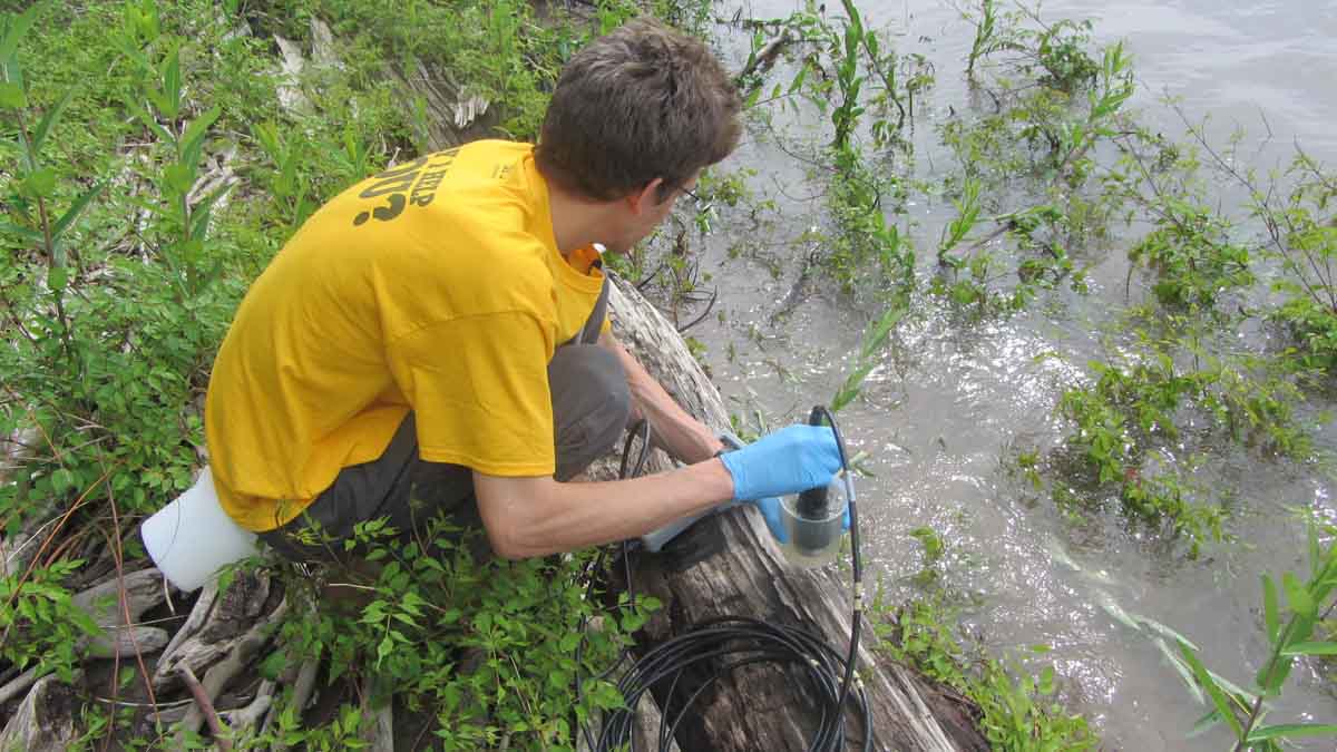 person taking samples from a river