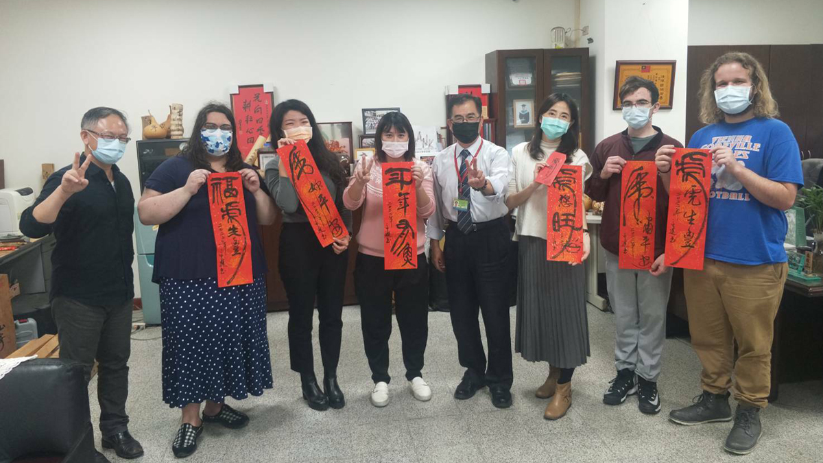 group of people, all masked, at Wenzao University, all holding Chinese calligraphy