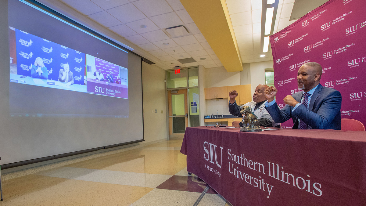 college officials celebrating after signing an agreement