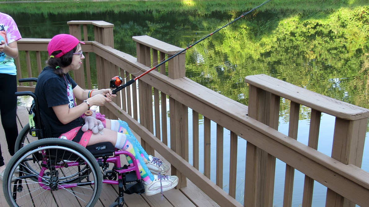 camper fishing from a bridge