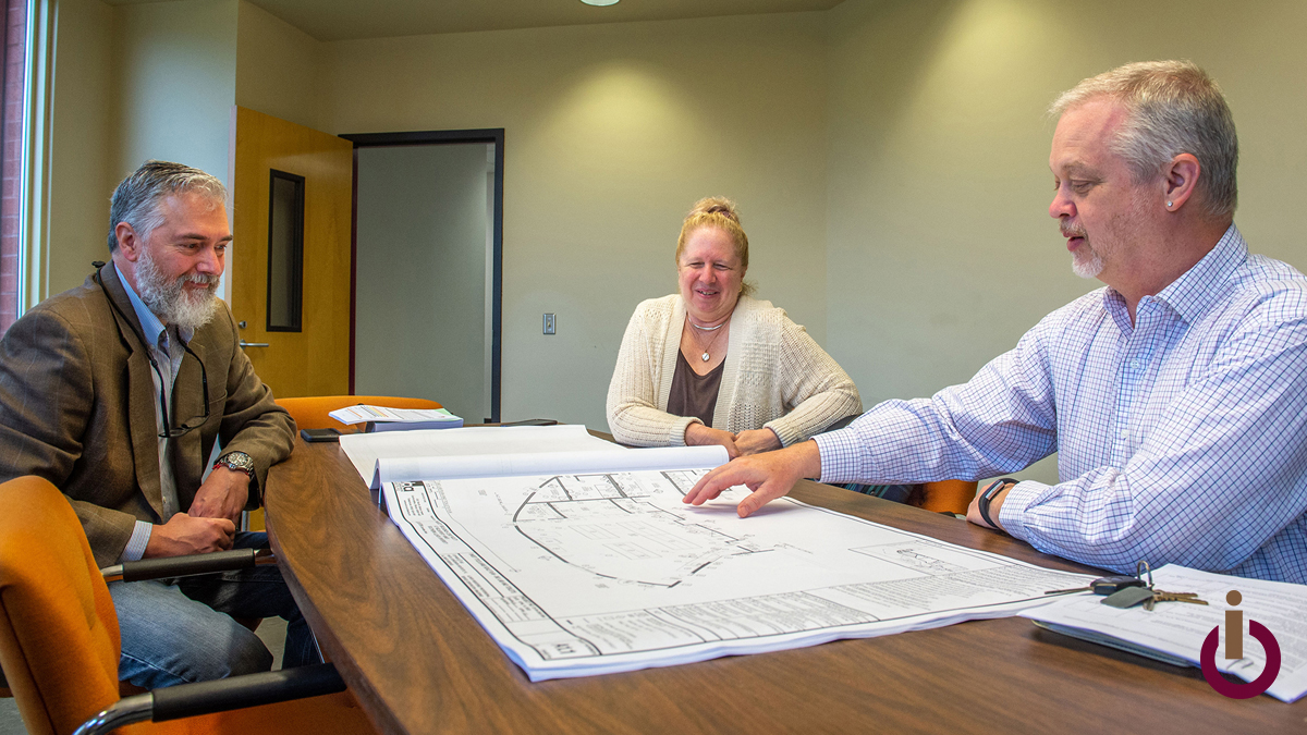 people looking at blueprints on a table