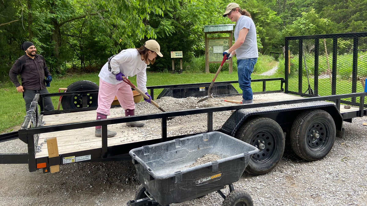 students shoveling rock while doing community projects