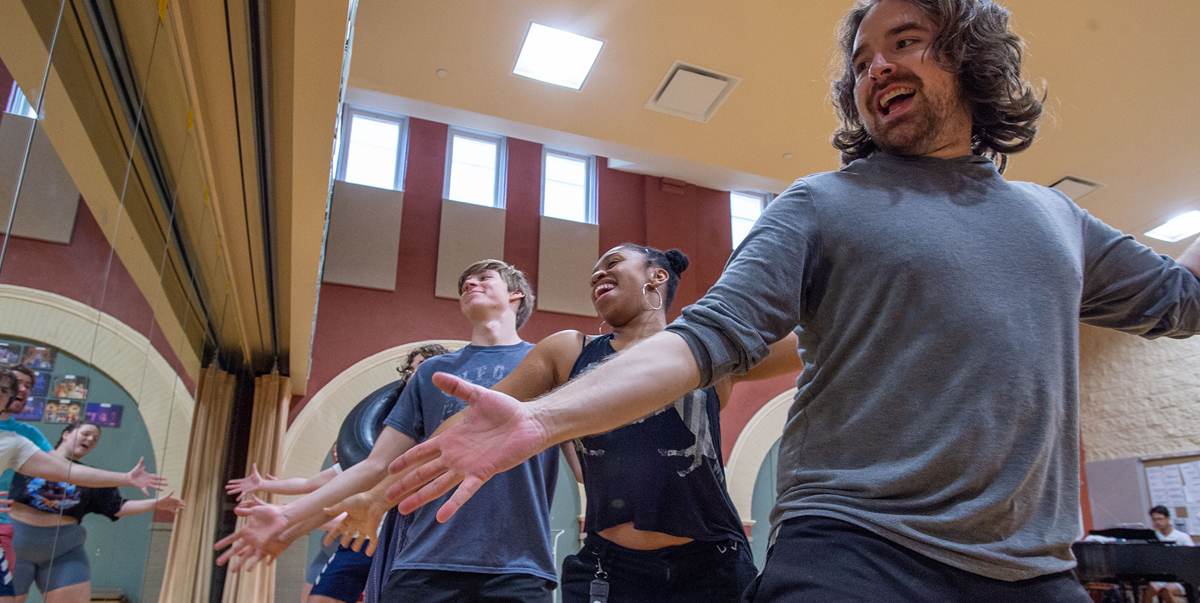 men and women rehearsing in front of a mirror