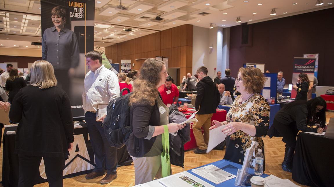 students and business leaders talking at a job fair
