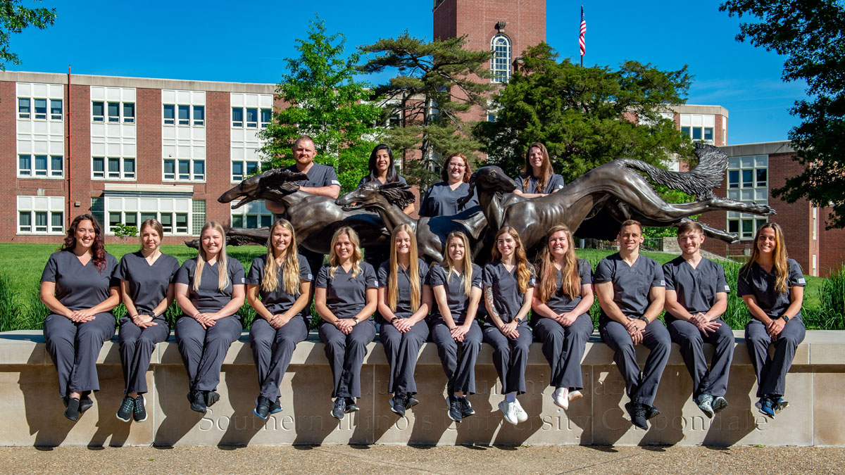 nursing students standing in front of Saluki statues