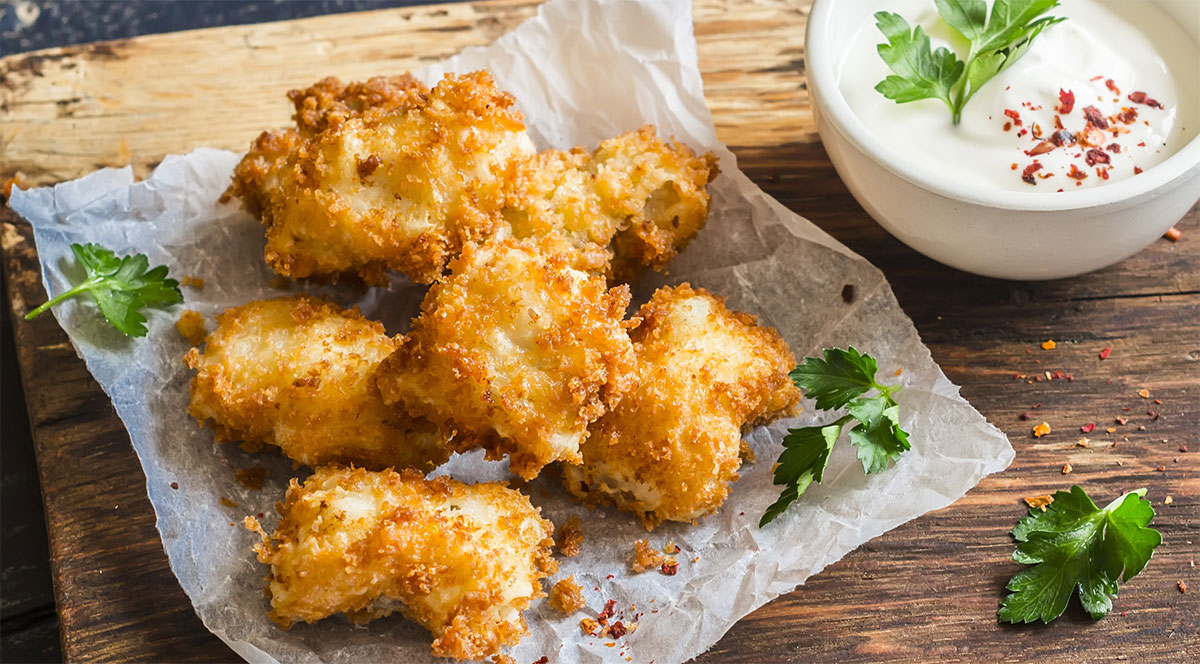 fried fish nuggets on paper with parsley sprinkled around