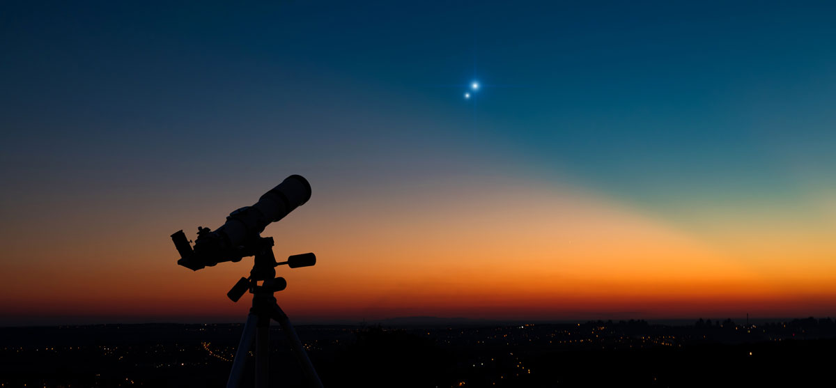 Silhouette of a astronomy telescope with twilight sky