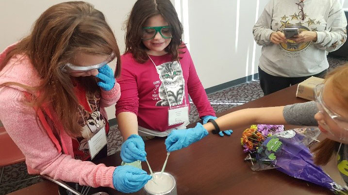 Three young girls, working on a science experiment