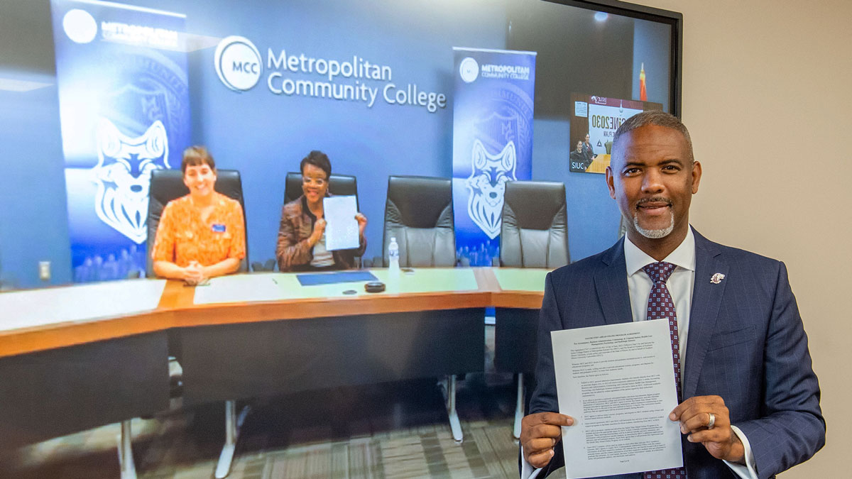 people smiling while holding newly signed documents