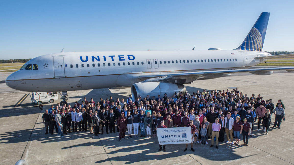 Members of the 2019 United Airlines-SIU Aviation Career Day gathered in front of a large airplane