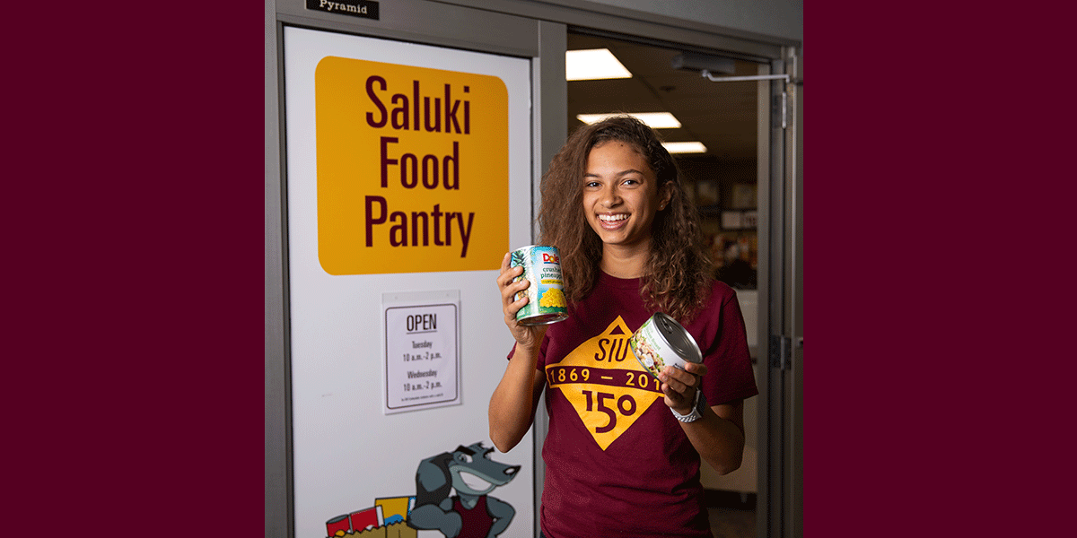 Young woman, smiling, holding canned food items.