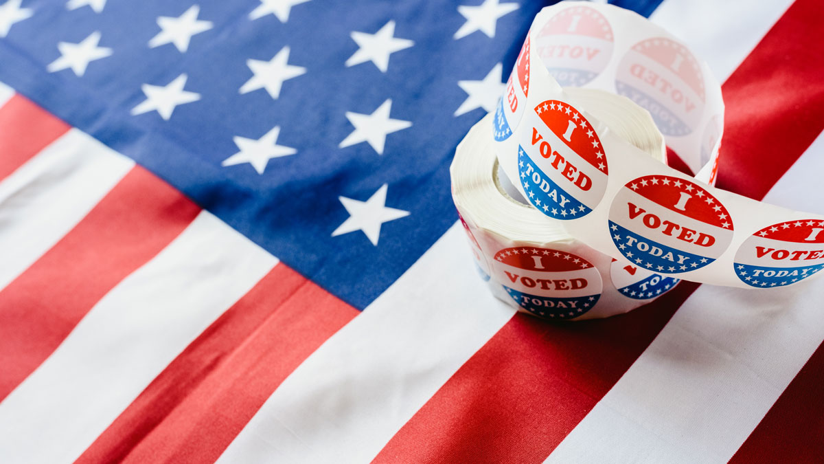 Roll of 'I Voted Today' stickers lay upon an American flag