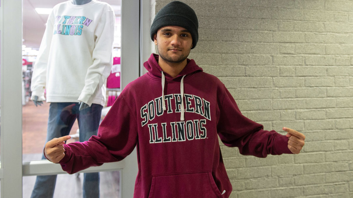 Young man wearing a black beanie and a maroon sweatshirt that says Southern Illinois