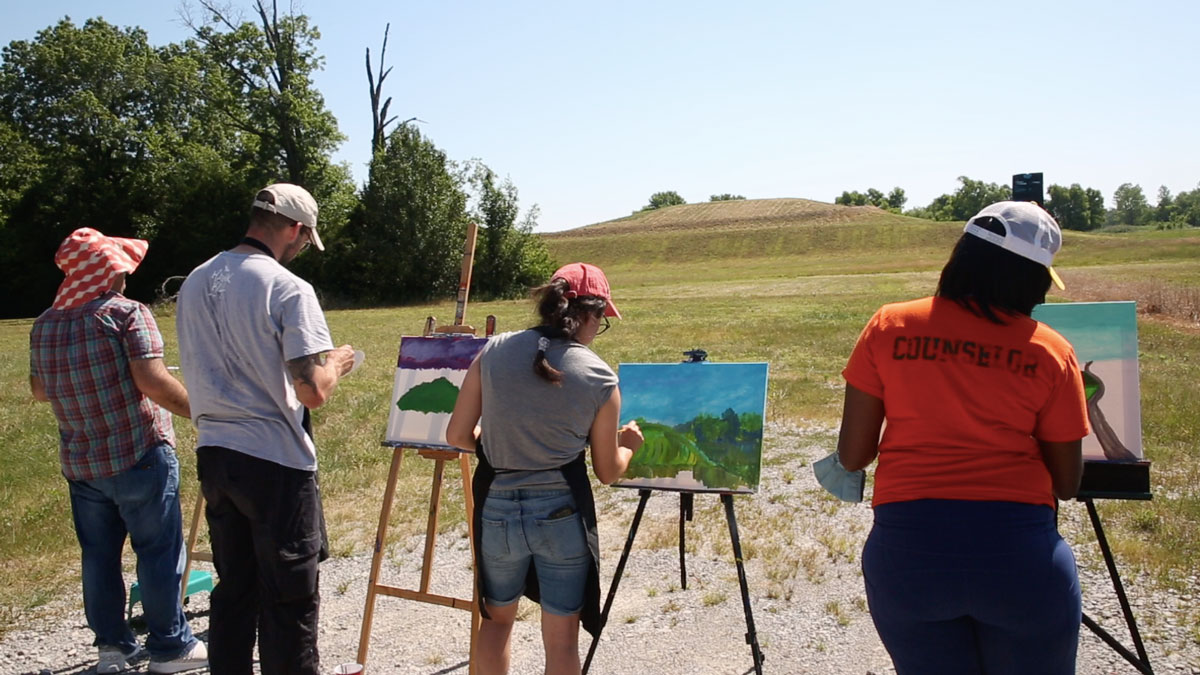 Students work on paintings at the former Koppers wood-treating site in Carbondale, IL