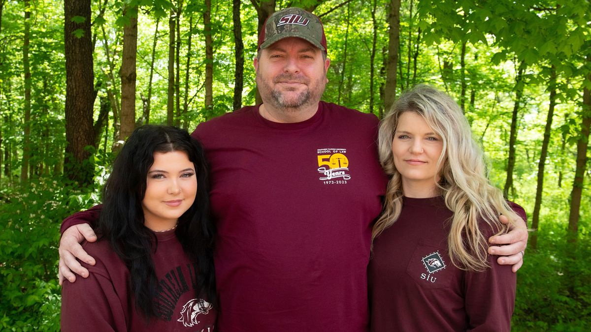 Ryan Taylor poses with his wife and daughter