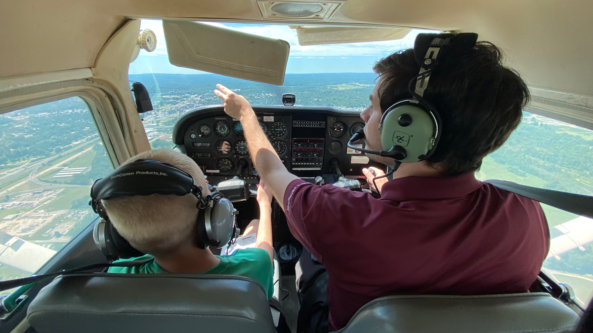 Pilot is taking a young child on a flight during Aviation Camp