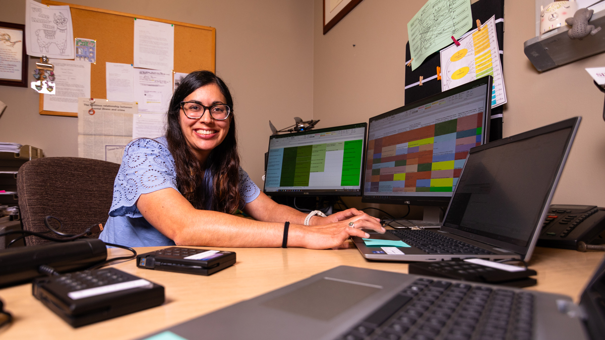 A woman is seated at a desk, working.