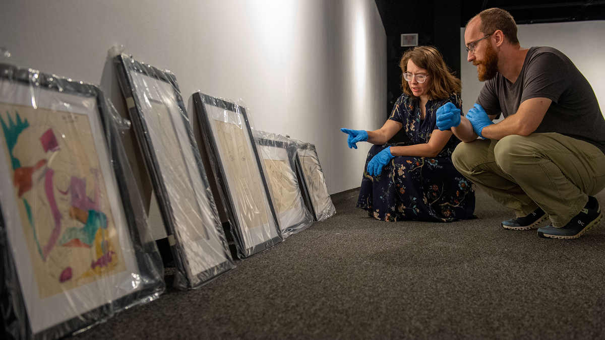 Two people discussing art and it's placement in a gallery