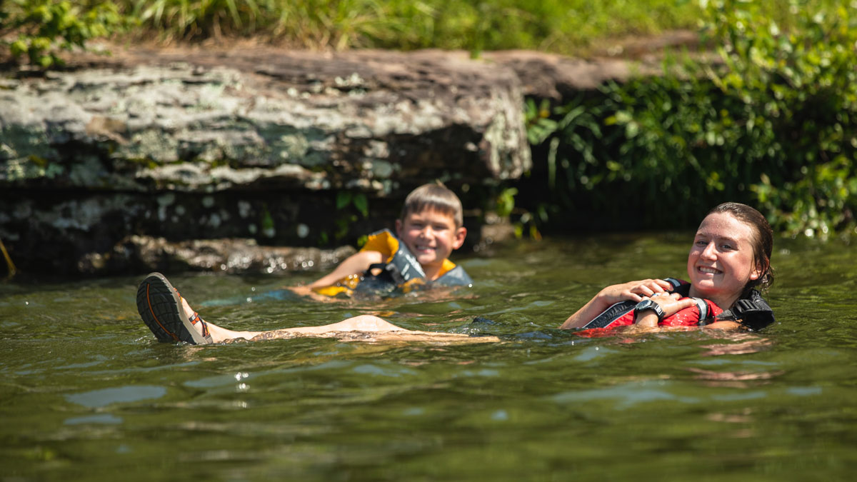 kids swimming while wearing life jackets