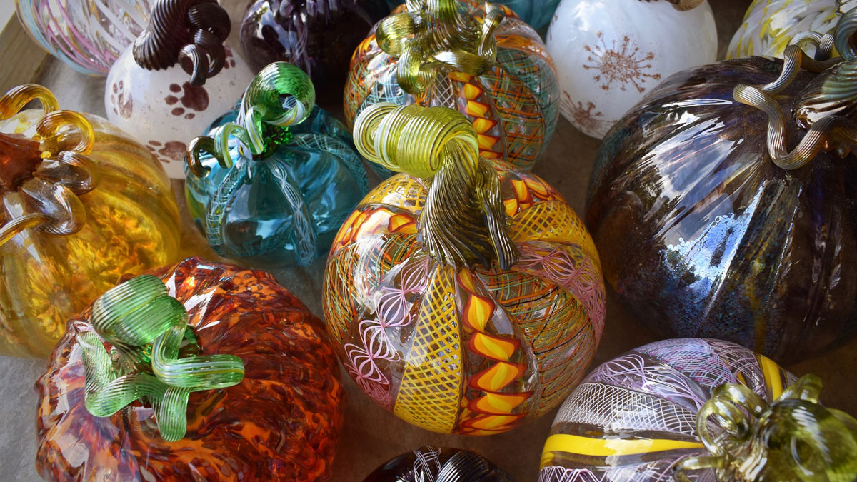 An assortment of glass pumpkins in many different colors.