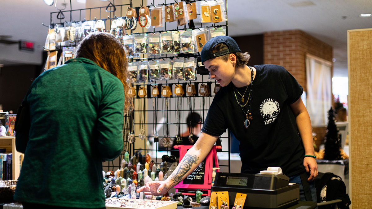 A craft show vendor talks with a customer