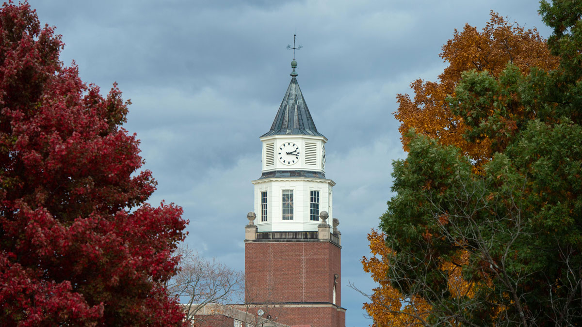 The clock tower on Pulliam Hall is seen through trees, showing off their fall colors