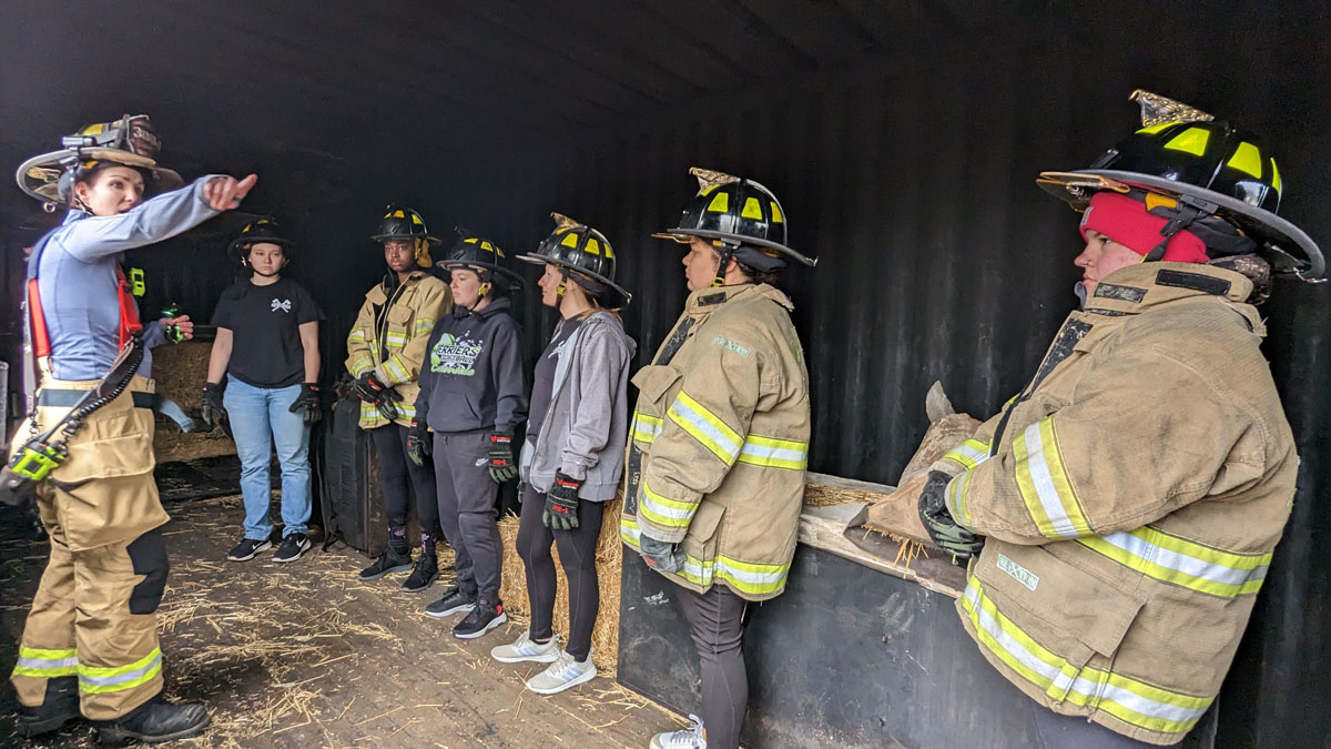 Female SIU students participating in a hands-on learning experience with  different fire fighting techniques