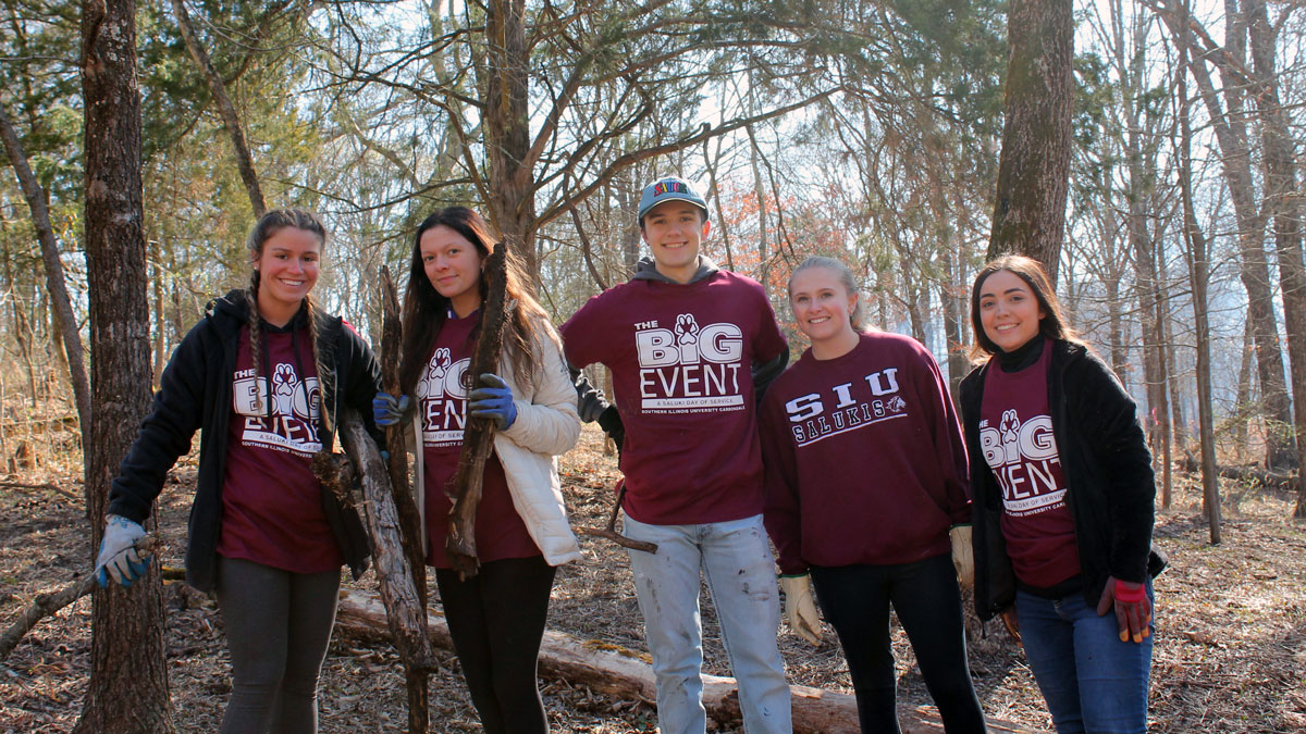 A group of students stops for a picture while performing community service projects during The Big Event.