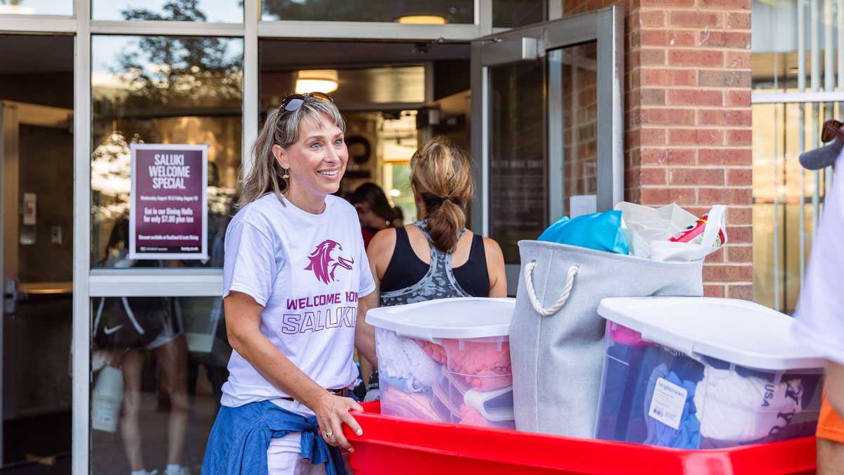 A woman is seen helping move students into student housing at the return of the semester.