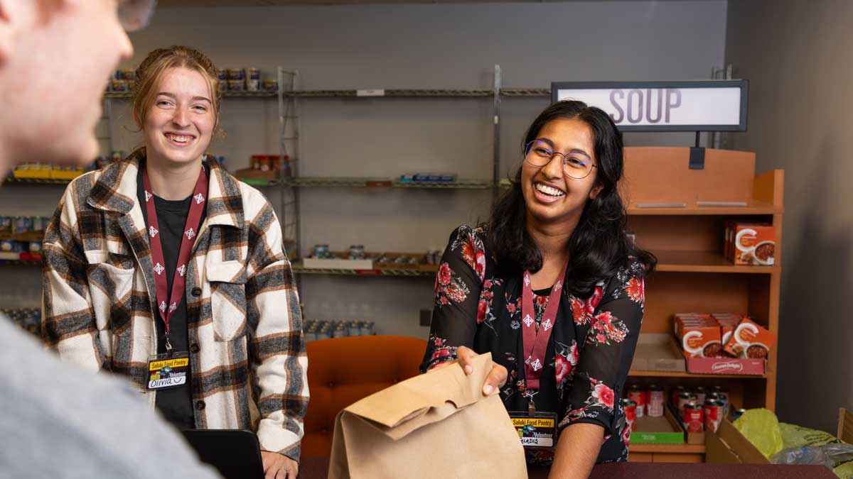 Two people working the checkout counter of the food pantry