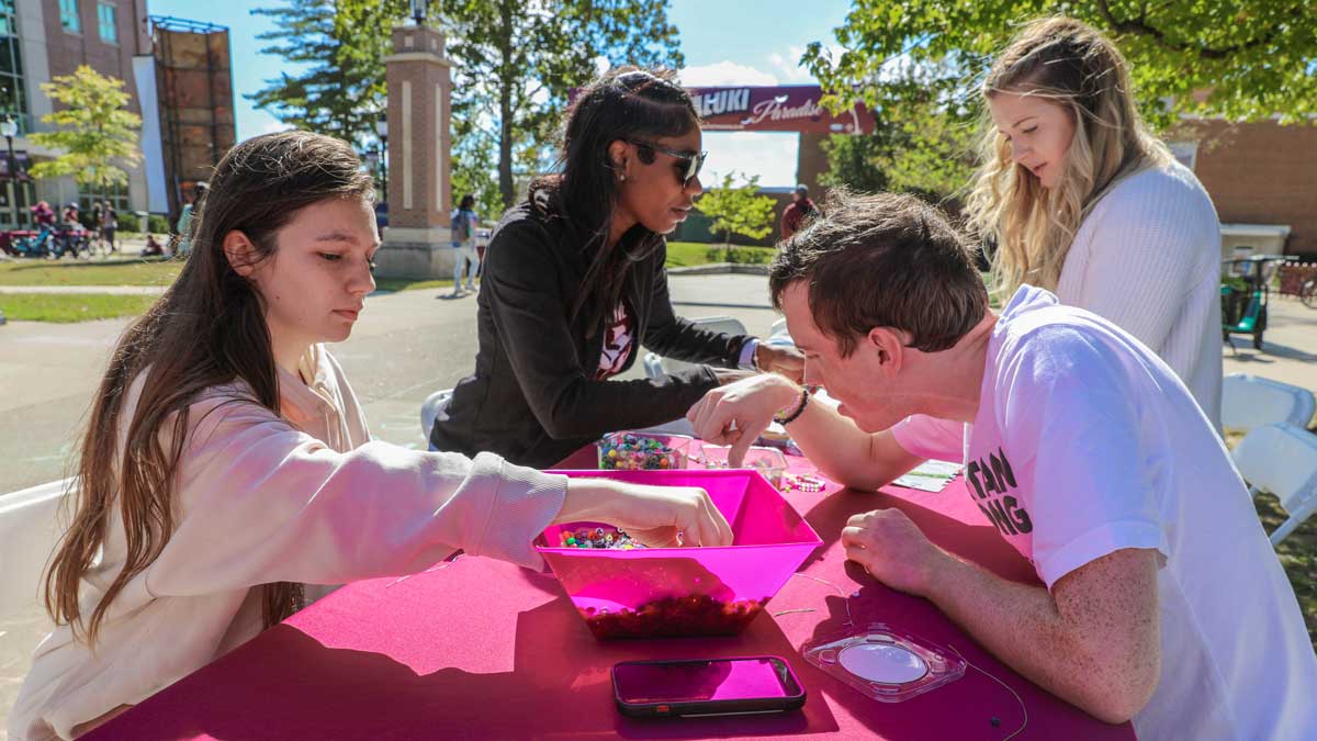 A group of students work on creating affirmation bracelets.