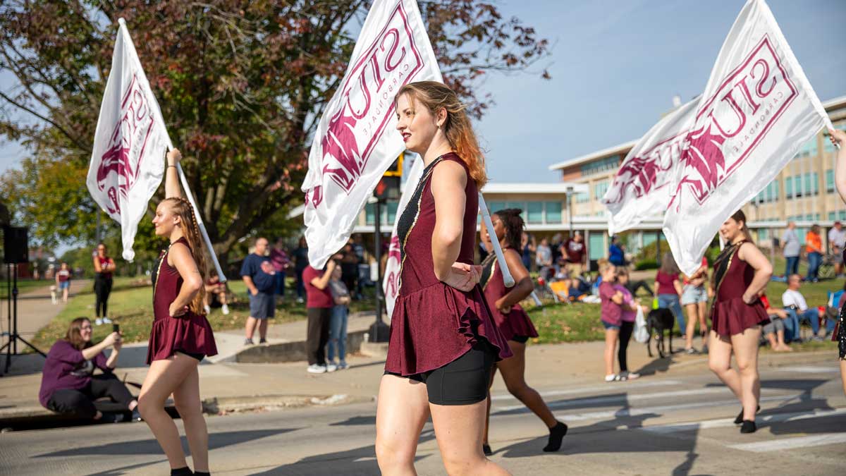 Marching Saluki color guard marches in a parade.