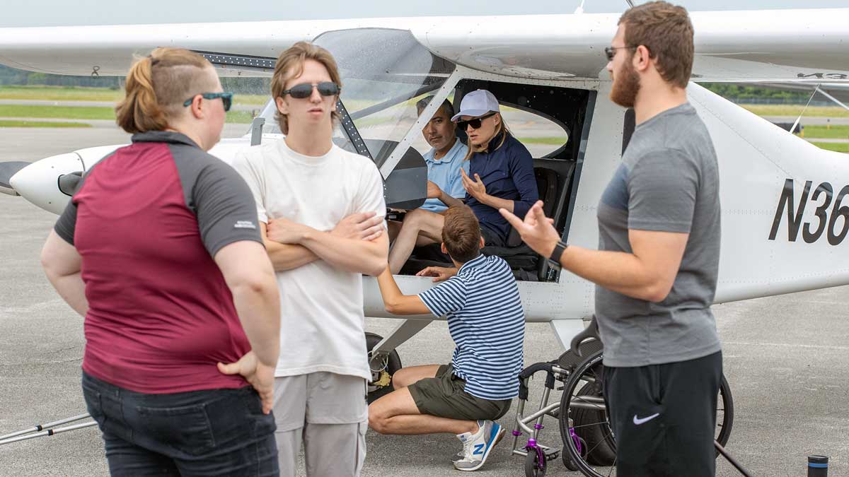 A group of people around a small plane