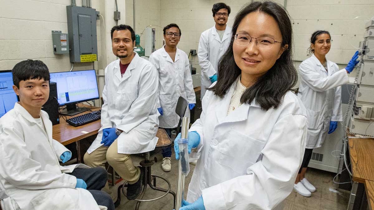 Professors and students working in a lab.