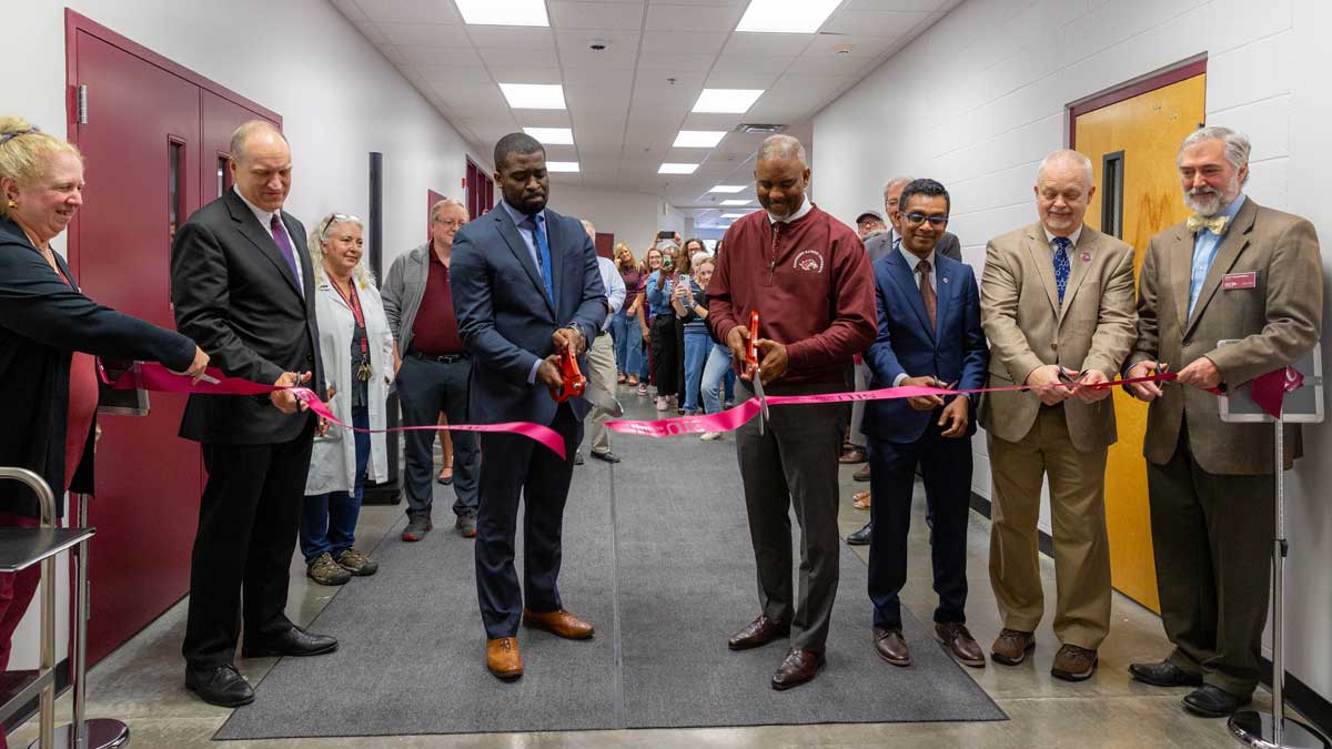 A group of people are attending a ribbon cutting ceremony