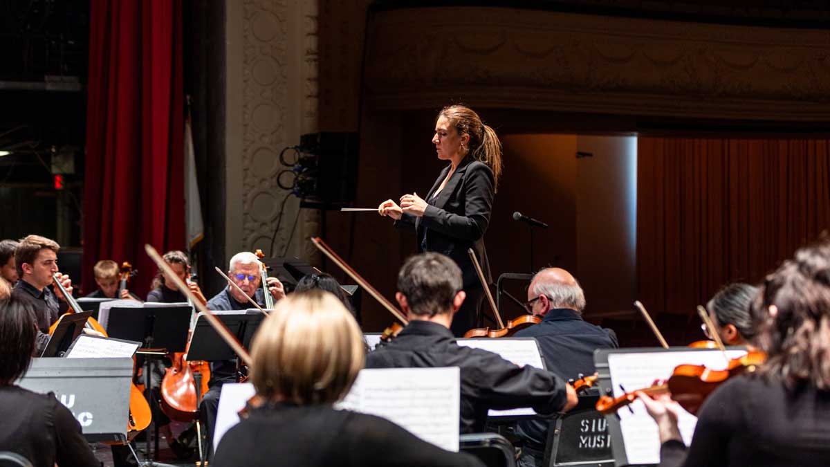 A woman is conducting an orchestra