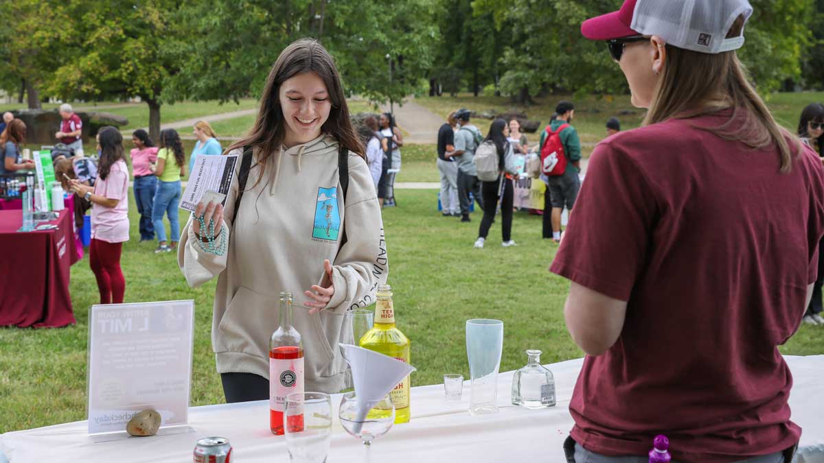 Two women speak at a booth about mental health and suicide prevention.