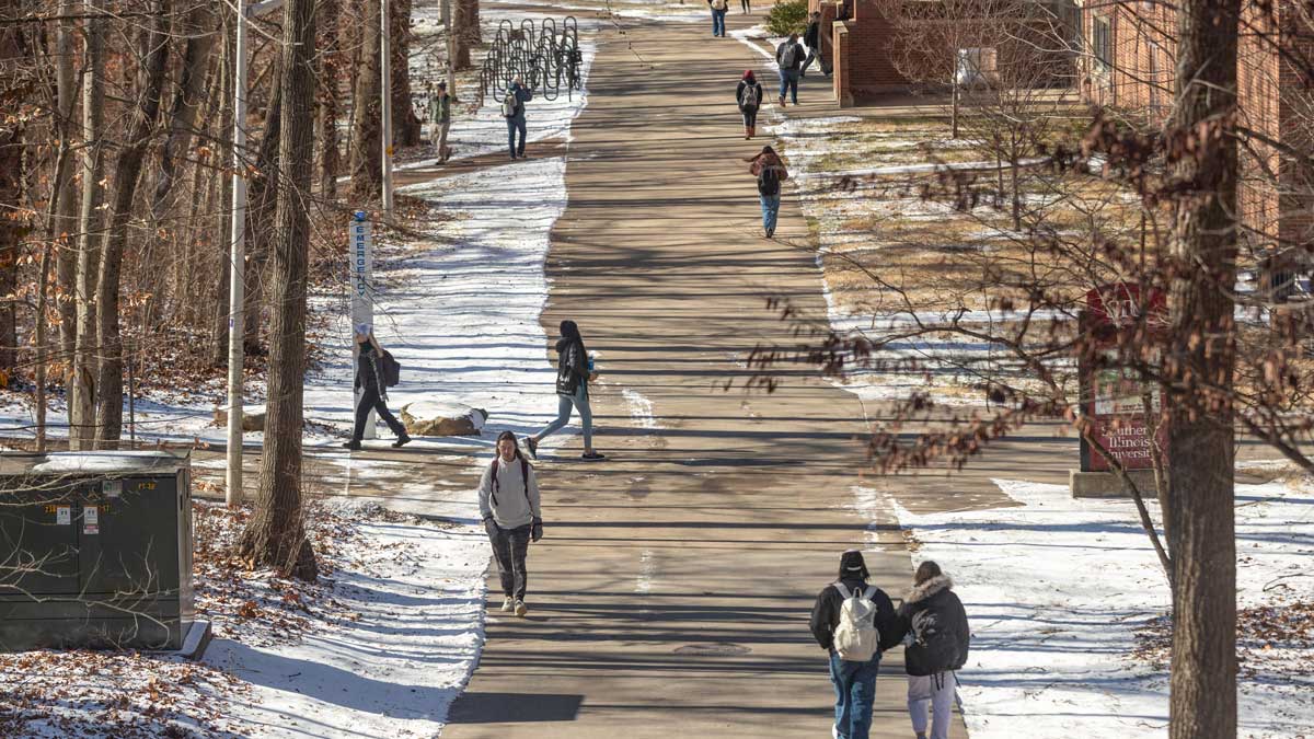 Students walking on campus. Snow is on the ground.