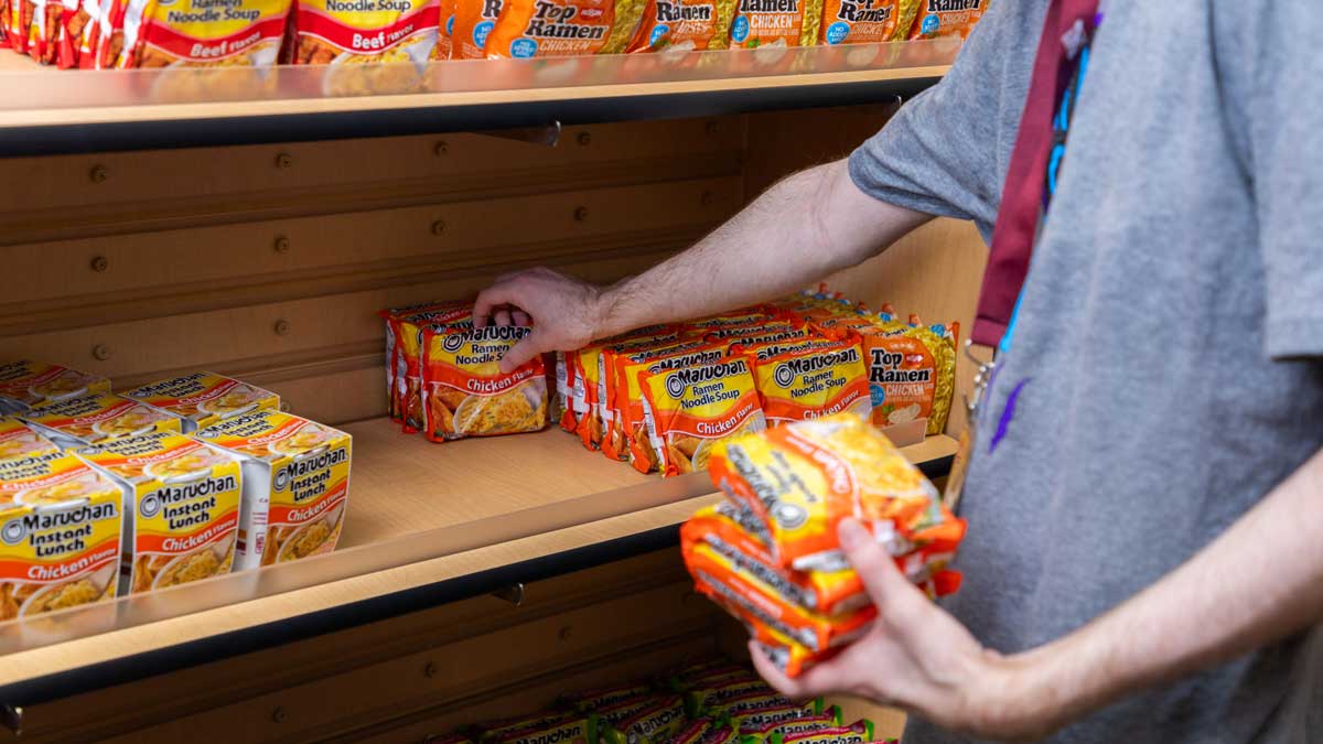 A worker is stocking shelves at a food pantry.