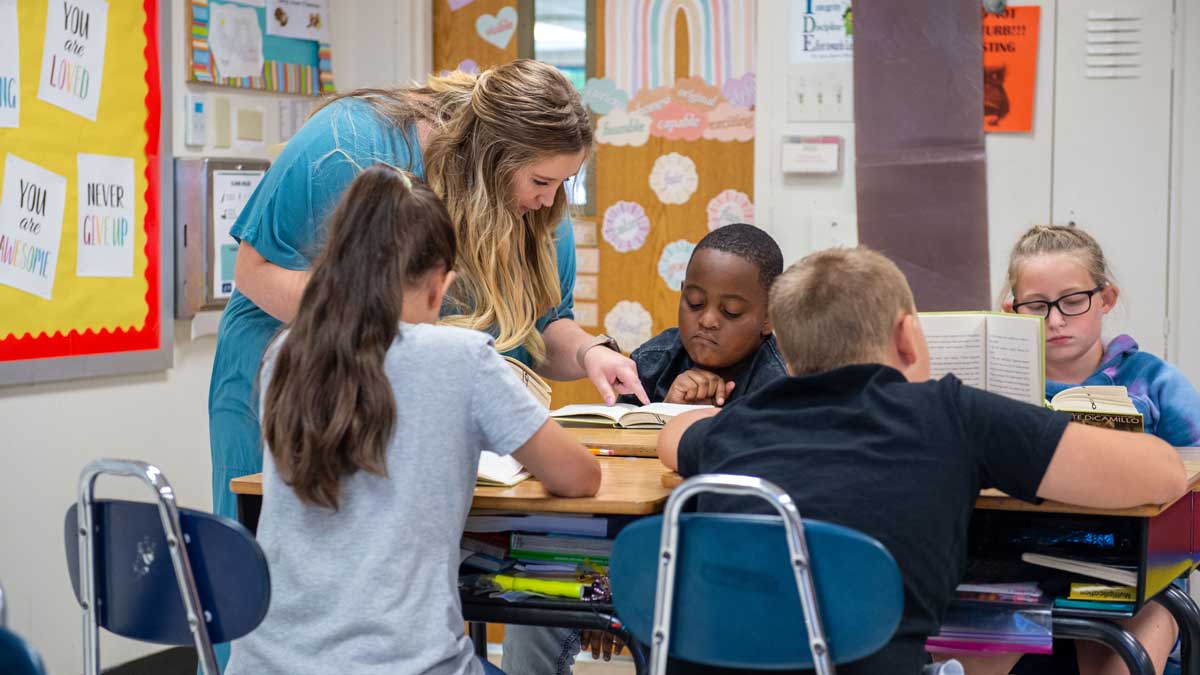 A young teacher is helping her students.