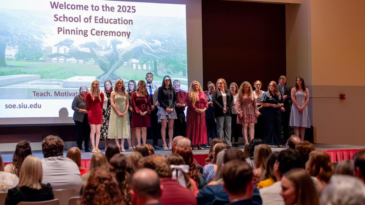 Students on stage at a teachers pinning ceremony.