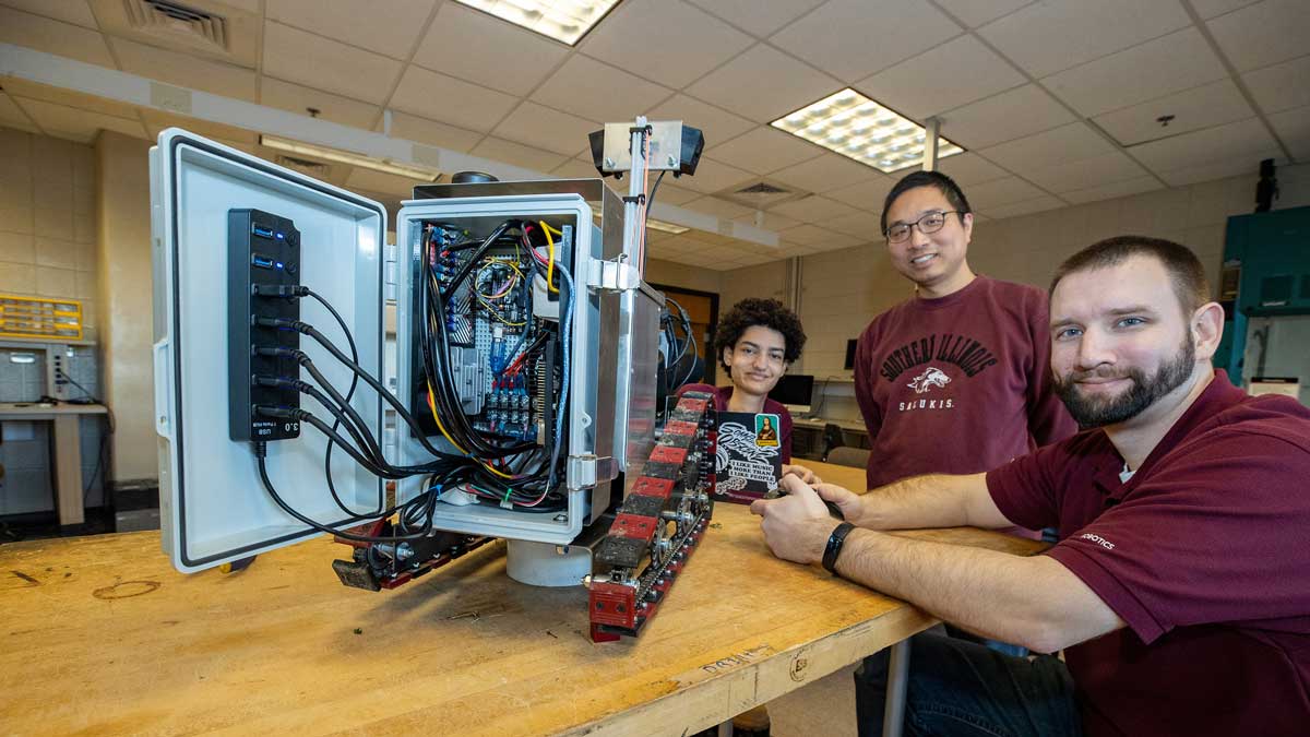 A group of people are seated around a robot built for plant inspection.